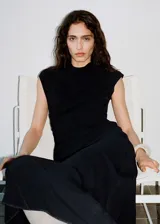 Vestido midi de diseño evasé con cuello perkins y sin mangas. Presenta cintura drapeada, cierre de cremallera en la parte posterior y forro interior.