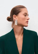 Blazer de corte recto y diseño estructurado, confeccionado en tejido mezcla de lana color verde oscuro. Presenta cuello con solapas de muesca, cierre frontal de doble botonadura, bolsillos de solapa laterales y bolsillo de ribete en el pecho. Incluye forro interior y mangas largas con puños abotonados.