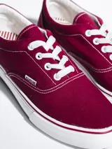 Championes de lona color azul grisáceo, estilo skate o casual, con cordones blancos y suela de goma blanca con una línea fina azul en el borde.