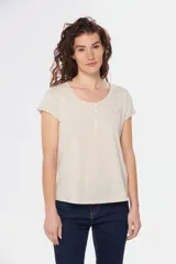Remera color beige con cuello redondo, mangas cortas, bolsillo pequeño en el pecho y media botonadura frontal.