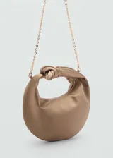 Bolso de mano tipo hobo confeccionado en tejido satinado color tostado. Presenta un diseño de media luna con un nudo decorativo en el asa superior, cierre de cremallera y forro interior.