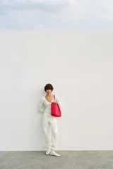Bolso de hombro tipo shopper con cuerpo satinado rojo, doble asa fina de hombro y cierre imantado.
