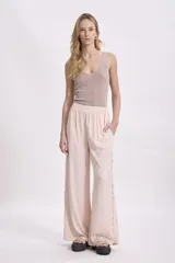 Blusa sin mangas de tejido de punto fino con acabado brillante, escote en V y corte ajustado al cuerpo.