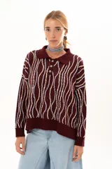 Buzo de punto color vino con diseño de rayas verticales irregulares en tonos claros. Presenta cuello polo con cierre frontal de tres botones, mangas largas con puños acanalados y corte holgado.