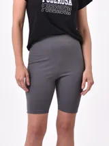 Biker de tiro alto, ajustada al cuerpo, confeccionada en tejido elástico de color gris.
