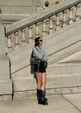 Botas de caña media color negro, con suela track y correas con hebilla plateada alrededor de la caña. El material es símil cuero.