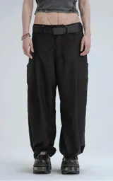 Pantalón sastrero de corte amplio y pierna recta, color negro. Presenta un tablón frontal que aporta estructura y bolsillos laterales de diseño limpio.