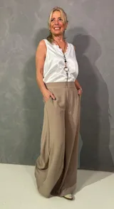 Pantalón estilo palazzo de color marrón claro, con bolsillos laterales, pretina frontal lisa y elástico en la espalda.