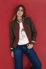 Chaqueta estilo militar Napoleón confeccionada en tela de paño de lana tweed color chocolate. Presenta cuello y puños en terciopelo de algodón color acero, decorada con cintas de pasamanería en tonos coral y oro, y botones empavonados.