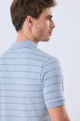 Remera polo de jersey color blanco, con diseño de rayas horizontales multicolores y cierre frontal de botones.