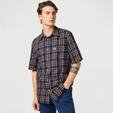 Camisa manga corta Wrangler a cuadros color azul y marrón, con cuello clásico, cierre frontal con botones y bolsillo en el pecho.
