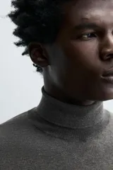 Jersey negro de punto fino con cuello alto y manga larga.