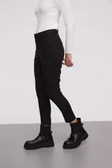 Pantalon de corte slim fit, color negro, con cierre frontal y bolsillos laterales.