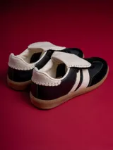 Zapatillas urbanas Champion Sicus color negro con detalles en blanco y suela color caramelo.