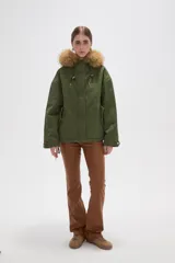 Campera negra de algodón con capucha, cierre frontal oculto y bolsillos laterales. Presenta un diseño holgado con detalles de piel sintética en el borde de la capucha.