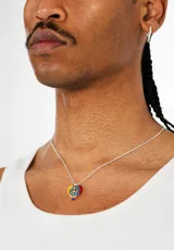 Collar de plata con cadena fina y dije en forma de corazón con los colores del arcoíris y un símbolo de la paz en el centro.