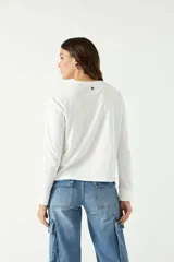 Remera manga larga color beige, con cuello bote y corte recto a la altura de la cadera.