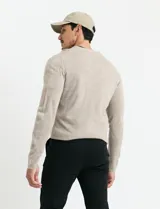 Sweater de punto con escote en V y manga larga, confeccionado en tejido acrílico con textura suave.