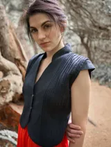 Chaleco negro con cuello mao, sin mangas y cierre frontal con botones.