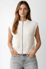 Chaleco de punto sin mangas, color blanco, con cierre frontal completo y cuello redondo acanalado.