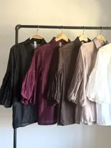 Camisa de organdí de algodón italiano en color bordó, con cuello camisero, cierre frontal con botones y mangas farol que aportan volumen.