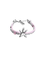 Pulsera de diseño artesanal con hilo de seda rosa, cuentas metálicas plateadas, cristales facetados rosas y dije central en forma de estrella de mar. Incluye cierre de mosquetón con cadena de ajuste y placa con logo de la marca.