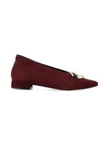 Zapato de punta fina en nobuck color bordeaux, con taco bajo y aplique metálico dorado en el empeine.