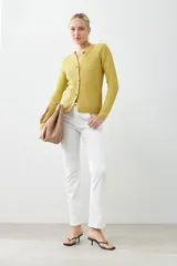Chaqueta de punto color verde oliva, con cuello redondo, cierre frontal de botones metálicos y dos bolsillos delanteros aplicados.