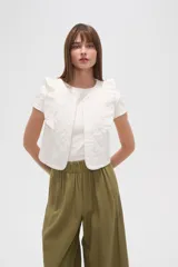 Chaleco corto de algodón con diseño capitoneado, cuello redondo y volados en los hombros.