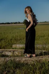 Conjunto de dos piezas compuesto por un top sin mangas con diseño bicolor en blanco y negro y detalle bordado frontal, y un pantalón de corte recto y ancho en color negro con bolsillos laterales y cintura ajustable.