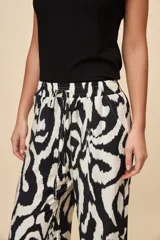 Pantalón ancho estampado de corte amplio y fluido, con cintura elastizada y lazo ajustable.