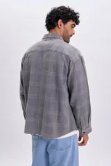 Sobrecamisa de franela color azul con patrón a cuadros, manga larga, bolsillos frontales con solapa y cierre de botones.