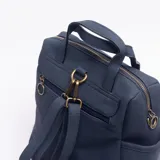 Mochila de diseño urbano en color azul, confeccionada en material texturizado. Cuenta con un compartimento frontal con cierre, asas superiores para llevar en la mano y bolsillos laterales abiertos.