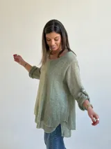 Sweater de tejido de punto color verde, de corte holgado y acampanado, con cuello redondo y mangas largas con presilla para arremangar.