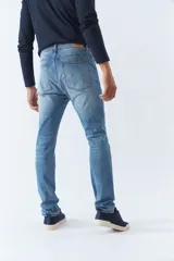 Pantalón jean de calce regular, color celeste con efecto lavado y roturas.