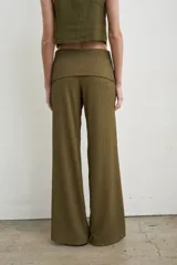 Pantalón palazzo negro de tiro alto con cintura ancha plegable, confeccionado en tela de punto fruncida y corte holgado.