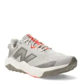 Championes de trail running New Balance modelo Nitrel v6, color gris con detalles en naranja neón. Presentan una capellada de malla técnica transpirable, refuerzos en la puntera con tecnología Toe Protect y suela AT Tread para mayor tracción en diversos terrenos.