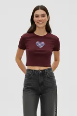 Remera de algodón color bordó, de corte ajustado y manga corta, con cuello redondo y aplique central en forma de corazón con estampado de cuadros.