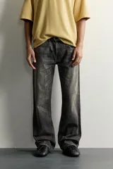 Jeans flare fit de denim de algodón en color gris con efecto lavado. Presentan diseño de cinco bolsillos, tiro medio y cierre frontal con cremallera y botón.