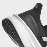Championes de running Adidas Ultraboost 5, color negro con tres franjas laterales blancas. Cuentan con mediasuela blanca con tecnología Light BOOST V2 y refuerzo de talón externo moldeado.