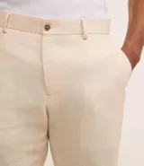 Pantalón de vestir azul marino, de corte relajado, confeccionado en tejido de viscosa y lino. Cuenta con cintura con trabillas, bolsillos laterales y traseros. Se ajusta a la cintura con cinturón de cuero marrón.
