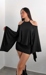 Vestido corto negro de diseño ajustado con escote halter y hombros descubiertos. Presenta mangas largas acampanadas con caída fluida y estilo capa.