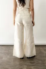 Pantalón de lino crudo, de tiro medio/alto, corte wide leg y elástico en la espalda.