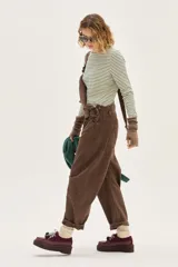 Borcego de cuero color bordó con suela de plataforma, cordones bicolores y detalle de pompones decorativos en el empeine.