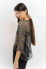 Blusa de red en color blanco con apliques de flores tridimensionales en toda la prenda. Presenta transparencias, cuello redondo y mangas largas.