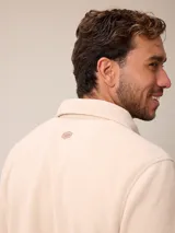 Sobrecamisa de polar azul marino con cierre frontal de botones a presión. Presenta bolsillos frontales con solapa, uno de ellos con cierre de cremallera adicional y detalles en contraste de material técnico.