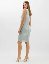 Conjunto de dos piezas compuesto por un vestido corto de silueta recta en tejido plisado metalizado con escote redondo adornado con pedrería y perlas, y una chaqueta de gasa liviana con frente abierto, caída en cascada y mangas tres cuartos con puños metalizados.