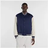 Campera estilo varsity con cuerpo azul marino y mangas en color beige. Presenta cierre frontal con botones a presión, cuello, puños y ruedo acanalados con rayas decorativas, y logo de la marca bordado en el pecho.