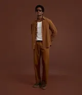 Pantalón de corte recto confeccionado en sarga de algodón con un toque de elastano. Presenta cintura con trabillas para cinturón, cierre tradicional de botón y cremallera, y bolsillos laterales y traseros.