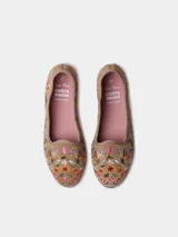 Bailarina de cuero serraje color beige, con detalle de flores bordadas en el lateral y suela plana con costura lateral visible.
